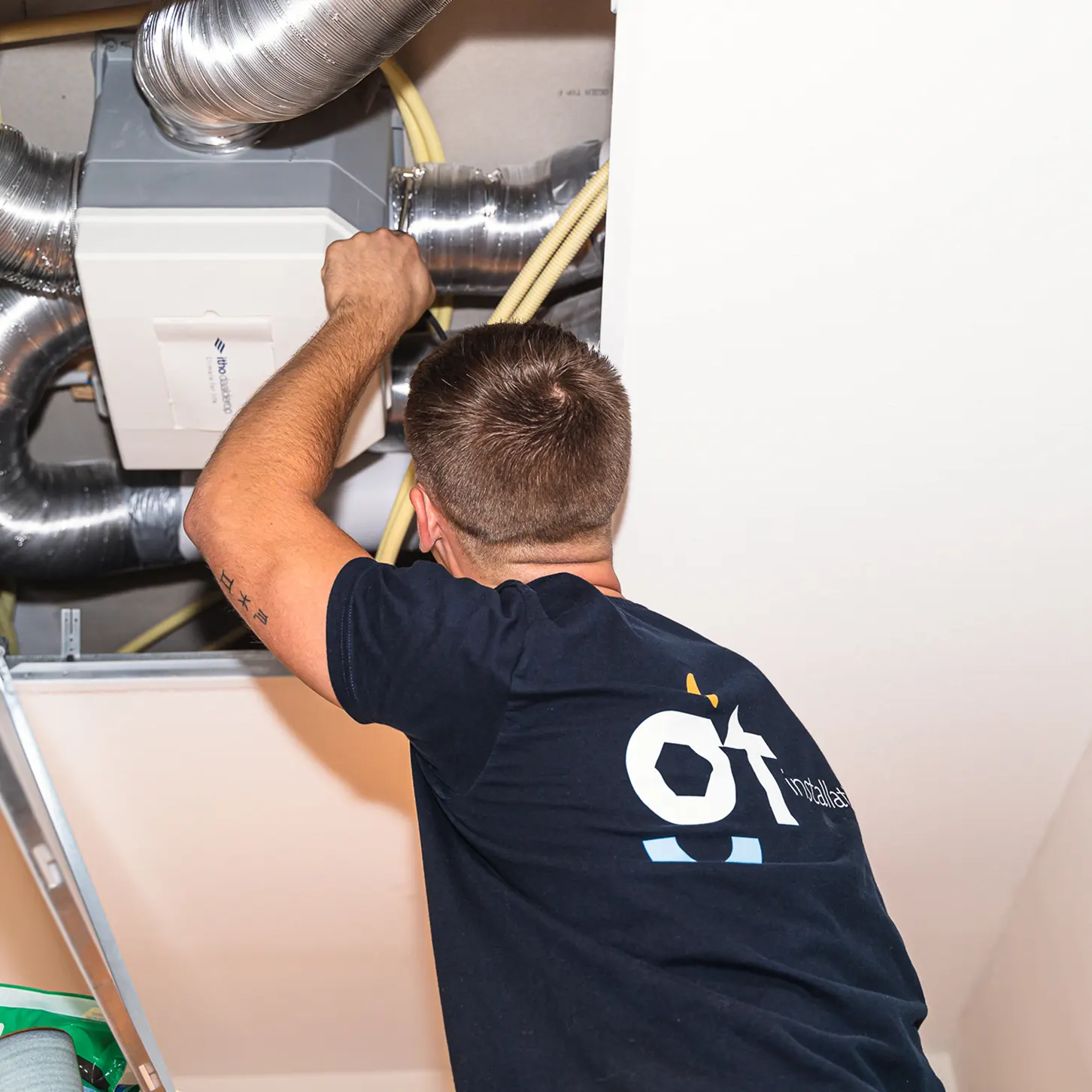 Installatiemonteur van GT Installatie werkt aan ventilatiesysteem met luchtkanalen in woning voor optimale ventilatie en luchtkwaliteit.